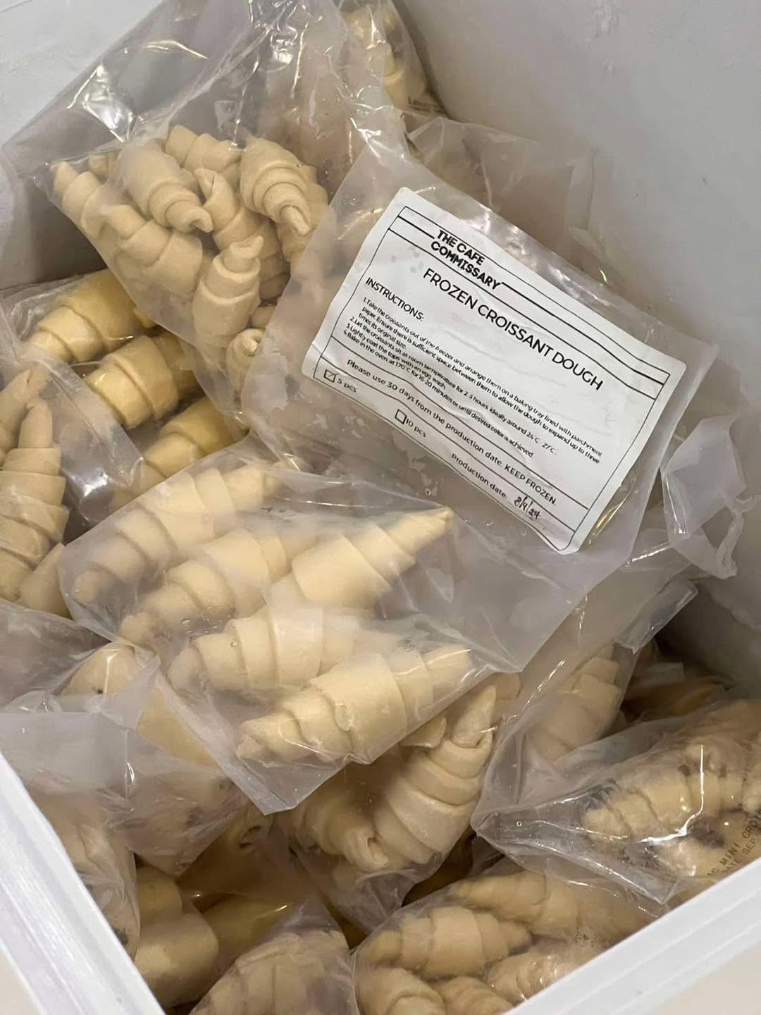 The Café Commissary–labeled frozen croissant dough, portioned and packed for partner cafés